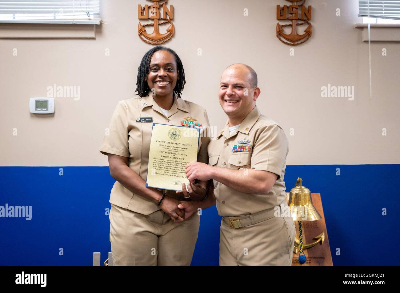 WASHINGTON, DC (May 27, 2021) – Lt. Takana Jefferson (left), Naval Support Activity Washington chaplain, and Chief Navy Counselor Eduardo Rivera (right) pose together with Rivera’s certificate of reenlistment onboard Washington Navy Yard. Stock Photo
