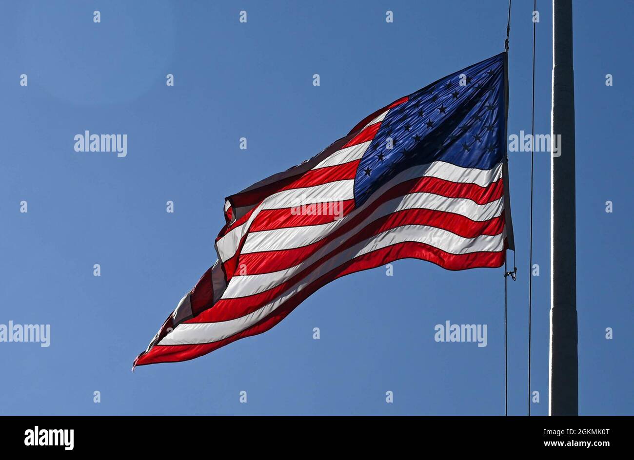 The United States Flag is lowered during the Memorial Day retreat ceremony at Joint Base Langley-Eustis, Virginia, May 27, 2021. The flag was then folded while the narrator explained the meaning of each fold. Stock Photo
