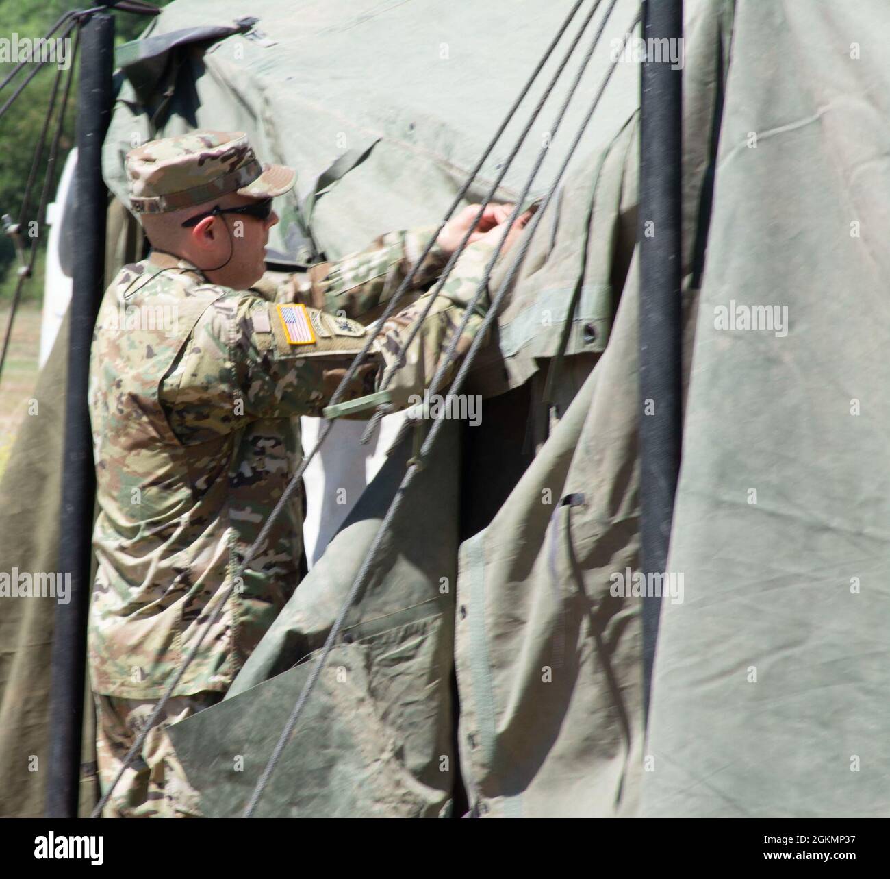 Army COL. Stanley Ostrem, Commanding Officer of the 561st Regional Support Group (RSG) laces the entry of a general purpose tent during construction, May 28, 2021, at a training site on Ft. Hunter Liggett, CA. The 561st RSG conducts annual training to keep abreast of U.S. Army and industry standard in logistics, personnel management and reintegration. Stock Photo