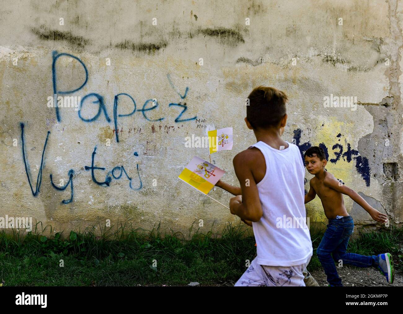 Kosice, Slovakia. 14th Sep, 2021. Boys play in front of the wall with sign 'Pope, welcome' at biggest Slovak Roma housing estate Lunik IX in Kosice before Pope Francis arrival to meet members of the Roma community, Slovakia, September 14, 2021, during his four-day visit to Slovakia, which started on Sunday. Credit: Roman Vondrous/CTK Photo/Alamy Live News Stock Photo