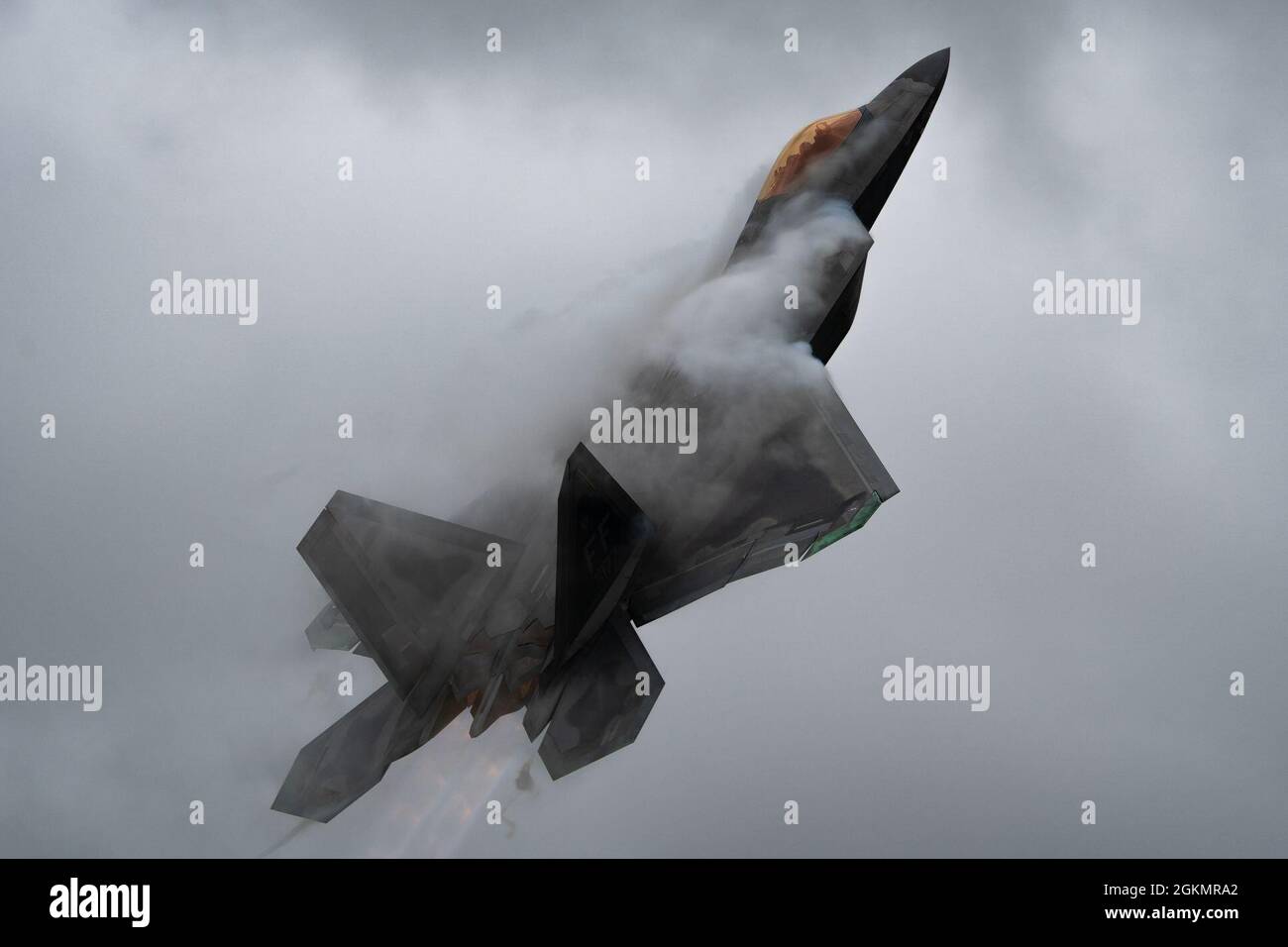 U.S. Air Force Maj. Josh Gunderson, F-22 Raptor Demo Team commander, performs a Pull Push Takeoff during an airshow demonstration during the Westmoreland County Airshow in Latrobe, Pennsylvania, May 29, 2021. The cloud that forms across the aircraft is due to a change in air pressure across the wing causing the moisture to condense into a visible vapor cloud. Stock Photo