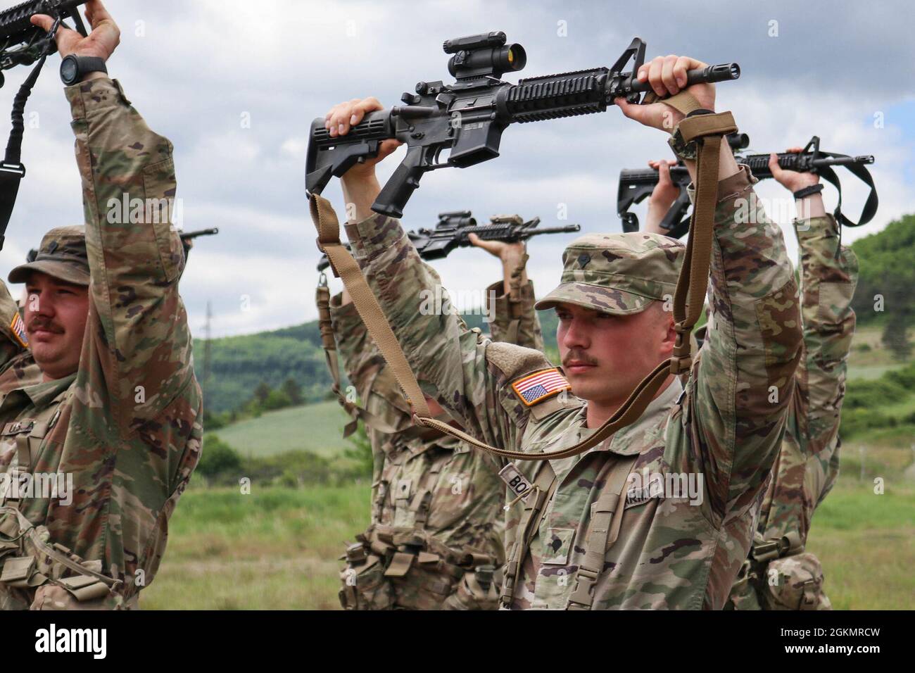 Iowa Army National Guard Soldiers holds their rifles above their heads