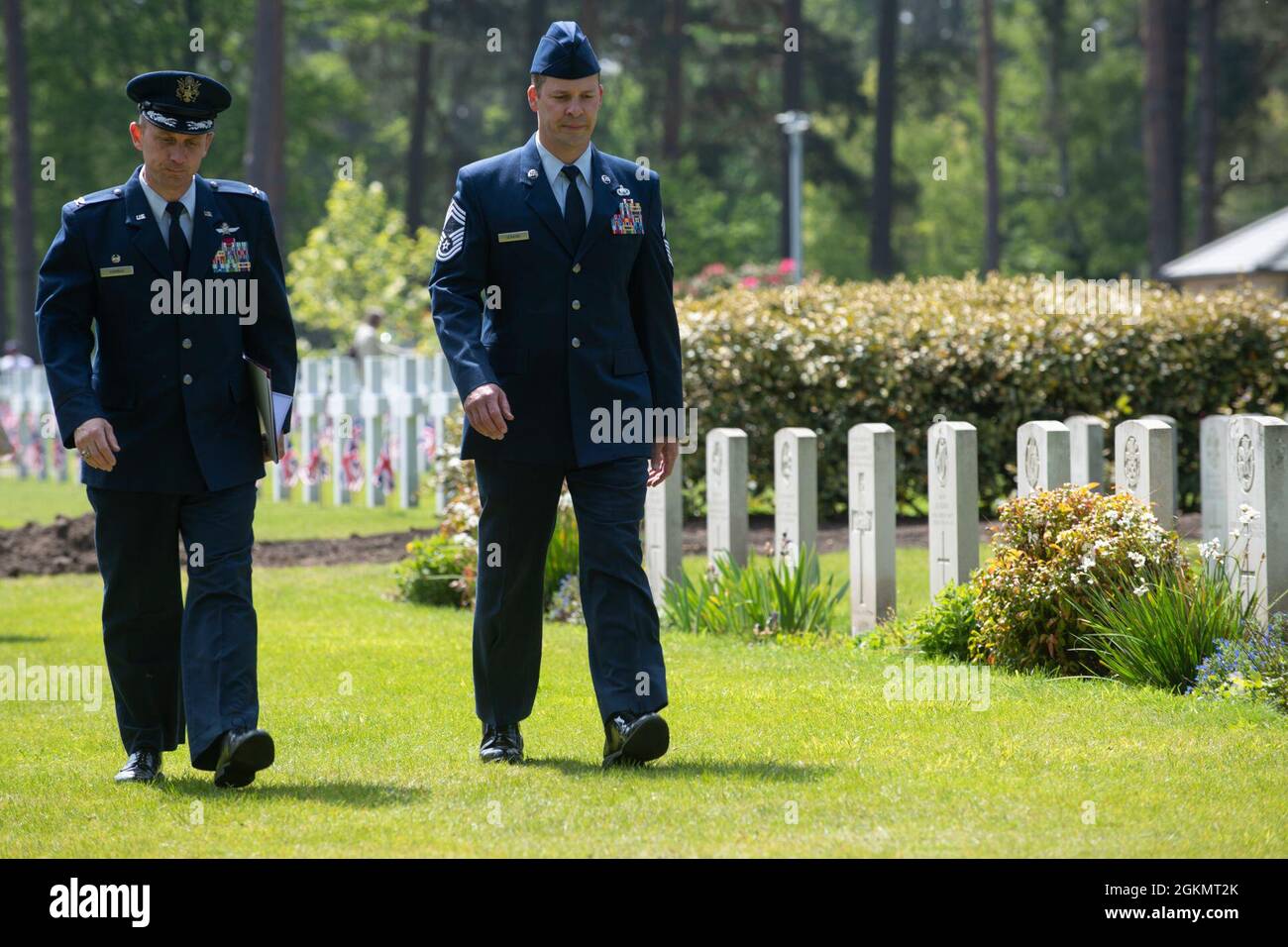 U.S. Air Force Col. Jon Hannah, left, 422nd Air Base Group commander, and Chief Master Sgt. Michael Venning, 422nd ABG superintendent, walk through the Brookwood American Military Cemetery, England, after a 2021 Memorial Day ceremony May 30, 2021. Memorial Day is one of our Nation's most solemn occasions. It serves as a chance to pause, reflect, and honor the women and men who gave the last full measure defending our Nation and our democratic ideals. Stock Photo