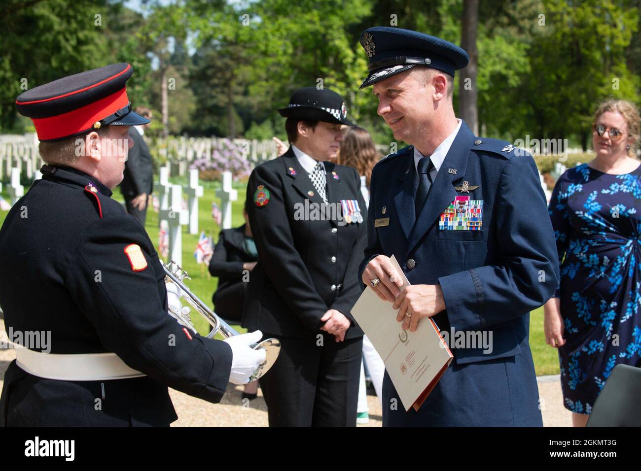U.S. Air Force Col. Jon Hannah, right, 422nd Air Base Group commander, talks with Bugler Heidi Watkins, left, Canadian High Commission, UK, at a 2021 Memorial Day ceremony at the Brookwood American Military Cemetery, England, May 30, 2021. Memorial Day is one of our Nation's most solemn occasions. It serves as a chance to pause, reflect, and honor the women and men who gave the last full measure defending our Nation and our democratic ideals. Stock Photo