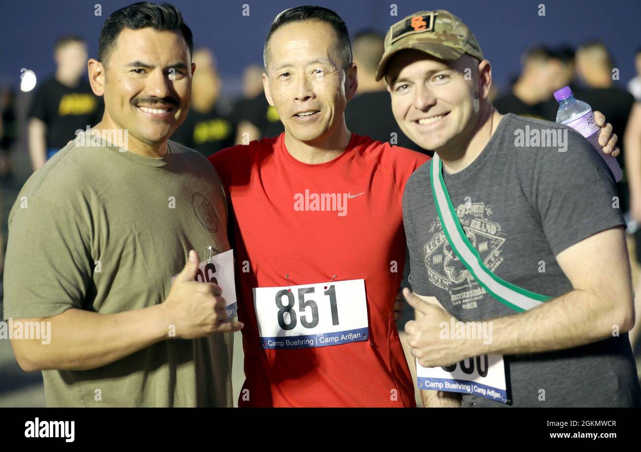 From left, Capt. Philippe Vasquez, Maj. Paul Lo and Capt. Daniel Burns pose for a photo before the Memorial Day 5K Run/Walk at Camp Buehring, Kuwait. Stock Photo