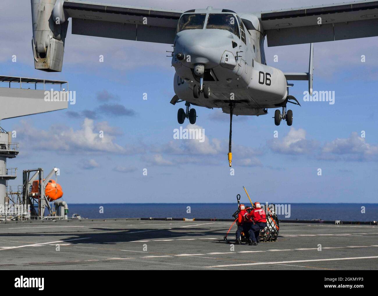 ATLANTIC OCEAN (June 1, 2021) Aviation Ordnanceman 3rd Class Angel Reyessuarez, left, and Aviation Ordnanceman 1st Class Matthew Watson prepare to hook up a training pallet to an MV-22 Osprey assigned to the Marine Medium Tiltrotor Squadron 261 (VMM-261) “Raging Bulls” during a deck landing qualification exercise (DLQ) aboard the Expeditionary Sea Base USS Hershel “Woody” Williams (ESB 4) in the Atlantic Ocean, June 1, 2021. Hershel “Woody” Williams is on a scheduled deployment in the U.S. Sixth Fleet area of operations in support of U.S. national interests and security in Europe and Africa. Stock Photo