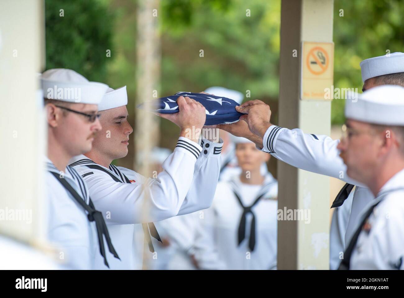 The Navy Region Hawaii Honor Guard folds the flag during a funeral for U.S. Navy Gunner’s Mate 3rd Class Shelby Treadway, 25, of Manchester, Kentucky, at the National Memorial Cemetery of the Pacific, Honolulu, Hawaii, June 2, 2021. Treadway was assigned to the USS Oklahoma, which sustained fire from Japanese aircraft and multiple torpedo hits causing the ship to capsize and resulted in the deaths of more than 400 crew members on Dec. 7, 1941, at Ford Island, Pearl Harbor. Treadway was recently identified through DNA analysis by the DPAA forensic laboratory and laid to rest with full military Stock Photo