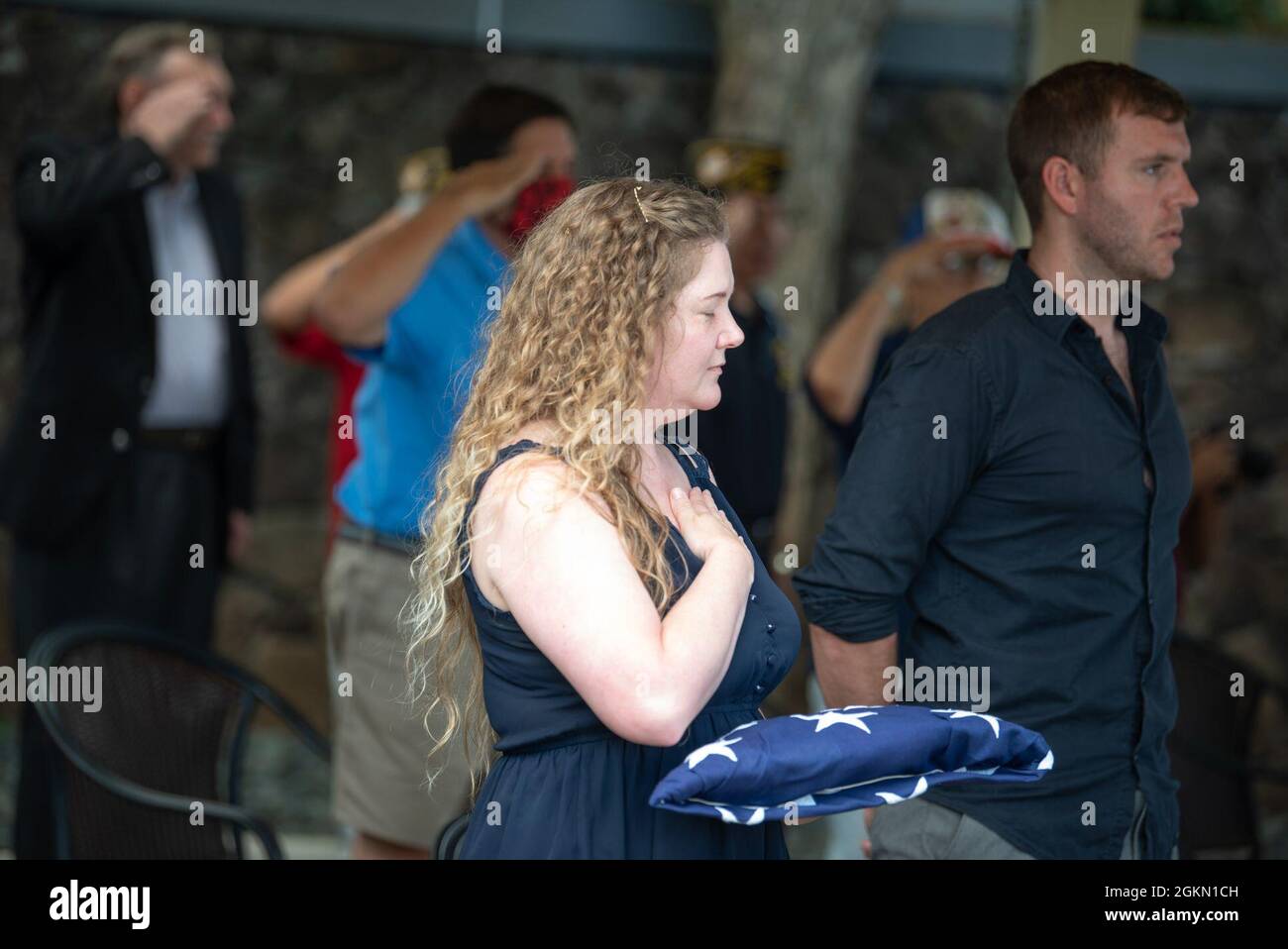 Sarah Adams, great-grandniece of U.S. Navy Gunner’s Mate 3rd Class Shelby Treadway, 25, of Manchester, Kentucky, places her hand on her heart after being presented a flag by sailors assigned to Navy Region Hawaii during her granduncle's funeral at the National Memorial Cemetery of the Pacific, Honolulu, Hawaii, June 2, 2021. Treadway was assigned to the USS Oklahoma, which sustained fire from Japanese aircraft and multiple torpedo hits causing the ship to capsize and resulted in the deaths of more than 400 crew members on Dec. 7, 1941, at Ford Island, Pearl Harbor. Treadway was recently identi Stock Photo