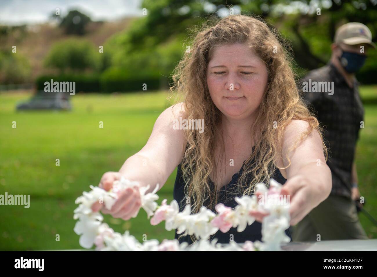 Sarah Adams, great-grandniece of U.S. Navy Gunner’s Mate 3rd Class Shelby Treadway, 25, of Manchester, Kentucky, places a wreath on her granduncle's casket during the funeral at the National Memorial Cemetery of the Pacific, Honolulu, Hawaii, June 2, 2021. Treadway was assigned to the USS Oklahoma, which sustained fire from Japanese aircraft and multiple torpedo hits causing the ship to capsize and resulted in the deaths of more than 400 crew members on Dec. 7, 1941, at Ford Island, Pearl Harbor. Treadway was recently identified through DNA analysis by the DPAA forensic laboratory and laid to Stock Photo