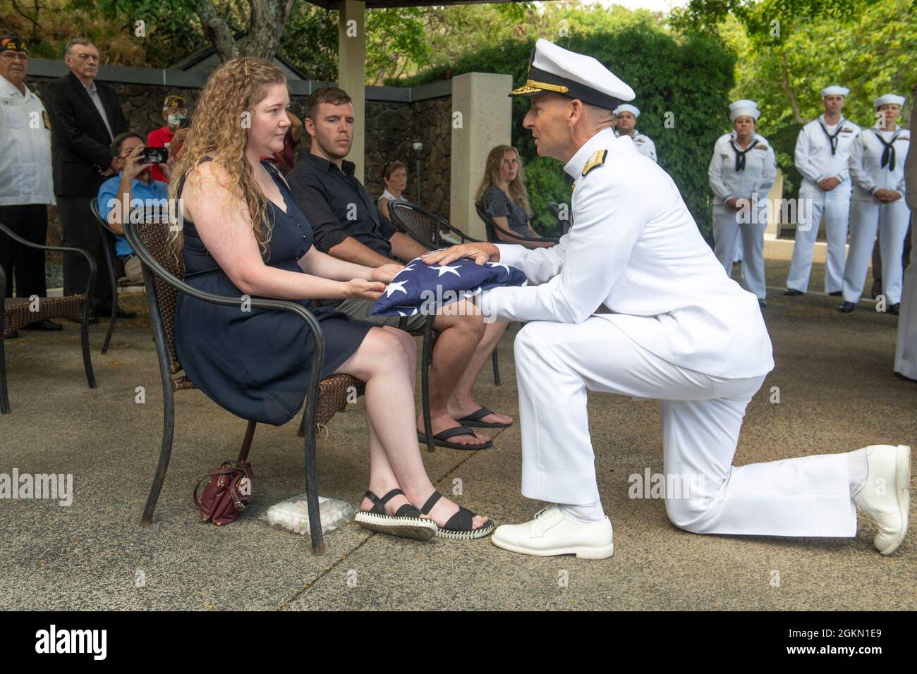 Sarah Adams, great-grandniece of U.S. Navy Gunner’s Mate 3rd Class Shelby Treadway, 25, of Manchester, Kentucky, is presented a flag by sailors assigned to Navy Region Hawaii during her granduncle's funeral at the National Memorial Cemetery of the Pacific, Honolulu, Hawaii, June 2, 2021. Treadway was assigned to the USS Oklahoma, which sustained fire from Japanese aircraft and multiple torpedo hits causing the ship to capsize and resulted in the deaths of more than 400 crew members on Dec. 7, 1941, at Ford Island, Pearl Harbor. Treadway was recently identified through DNA analysis by the DPAA Stock Photo