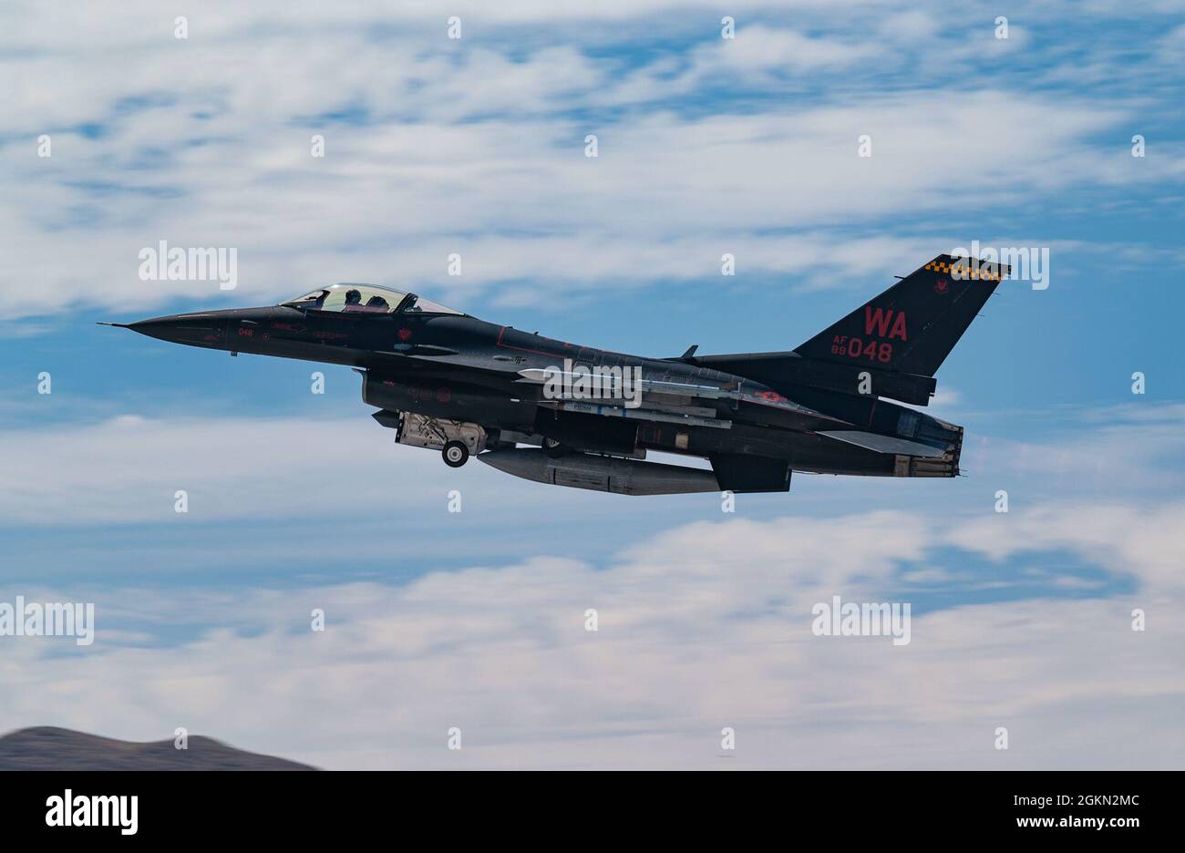 An F-16C Falcon fighter jet (Wraith) assigned to the 64th Aggressor Squadron (AGRS), takes off  during a U.S. Air Force Weapons School Integration exercise at Nellis AFB, Nevada, June 2, 2021. Aggressor pilots are highly skilled in adversarial tactics and provide realism to U.S. and allied forces during training exercises. Stock Photo