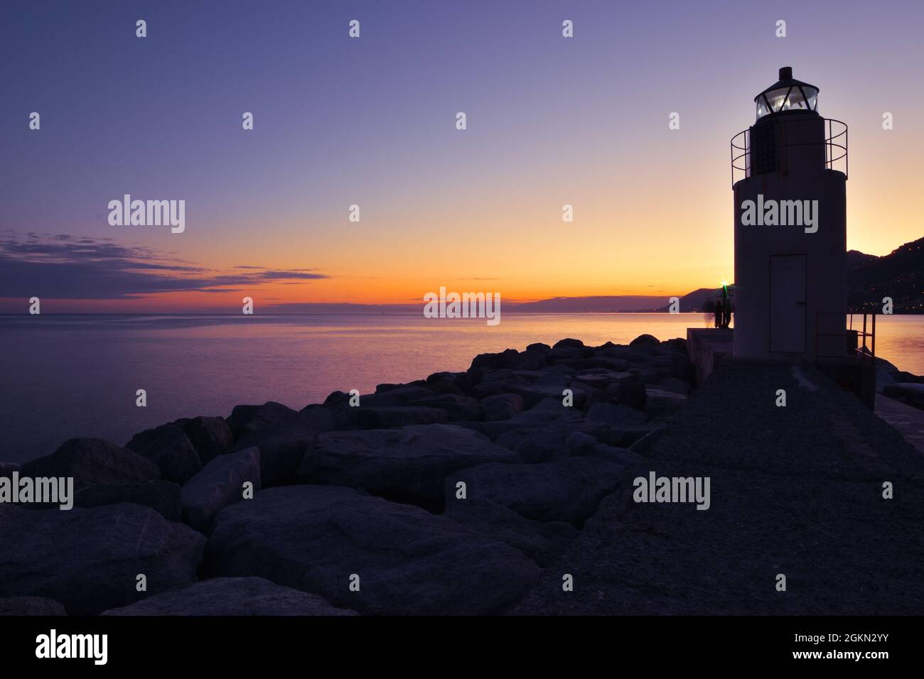 enchanting sunset over the sea with a view of the Camogli lighthouse Stock Photo