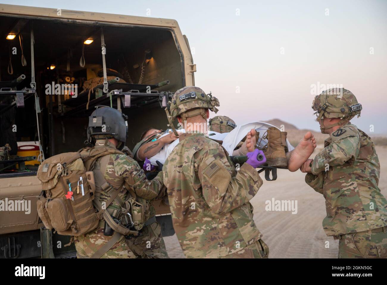 Medics of the 106th Support Battalion, Mississippi Army National Guard, carry a patient out of an M997A3 Ambulance at the National Training Center, Fort Irwin, California, June 2, 2021. The 106th remains prepared to provide medical services to Soldiers of the 155th Armored Brigade Combat Team and other supporting units while training at NTC. Stock Photo