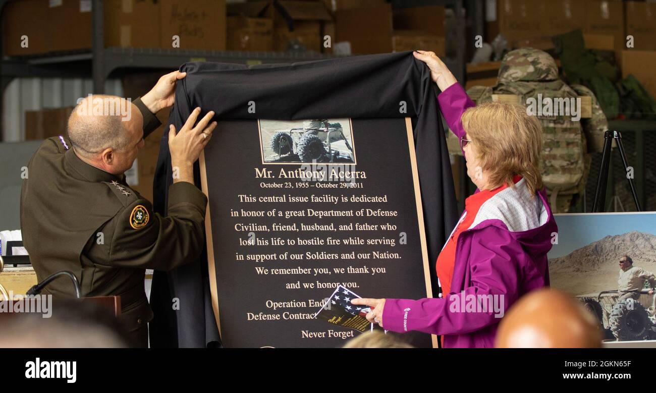 Lt. Gen. David G. Bassett, Director of the Defense Contract Management Agency, Fort Lee, Virginia, uncases the replica plaque with Linda Acerra, wife of former DCMA civilian employee Anthony A. Acerra, during a building dedication ceremony in his honor at Camp Atterbury, Indiana, June 3, 2021. Acerra was assigned to DCMA Central Afghanistan, Camp Phoenix, Kabul, Afghanistan on his fifth deployment when his convoy was attacked on October 29, 2011. Stock Photo