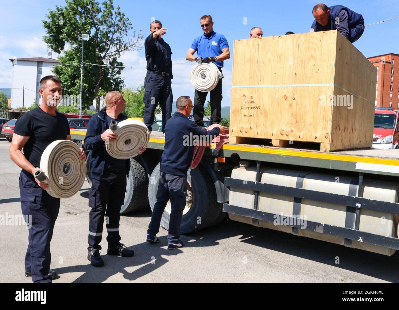 Members of the Camp Bondsteel and Ferizaj/Urosevac Fire Departments unload a crate of hoses in Ferizaj/Urosevac, Kosovo, on June 3, 2021. Working through the Kilo 21 Liaison Monitoring Team assigned to Regional Command-East, Kosovo Force, the CBS Fire Department donated 140 sections of hoses to the municipality’s only firefighting team. Stock Photo