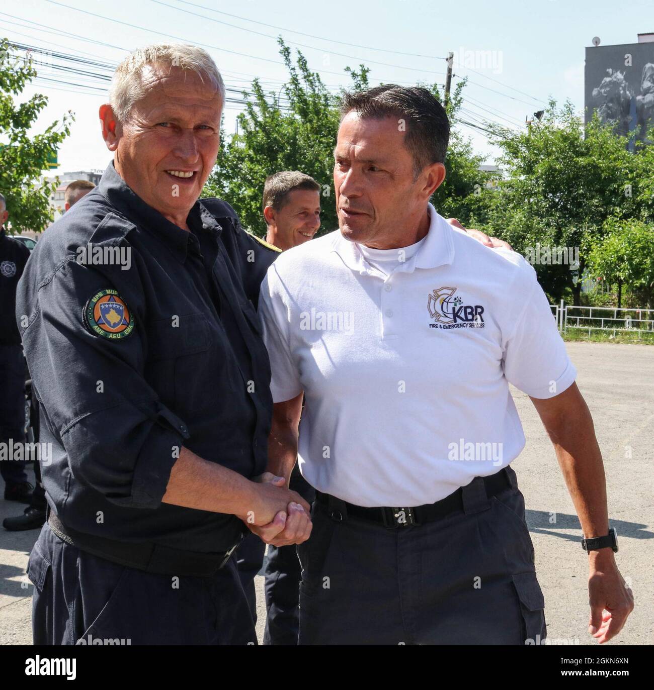 Matthew Williams, chief of the Camp Bondsteel Fire Department, shakes hands with Muje Hajdini, deputy chief of the Ferizaj/Urosevac Fire Department in Kosovo on June 3, 2021. Working through the Kilo 21 Liaison Monitoring Team assigned to Regional Command-East, Kosovo Force, the CBS Fire Department donated 140 sections of hoses to the municipality’s only firefighting team. Stock Photo
