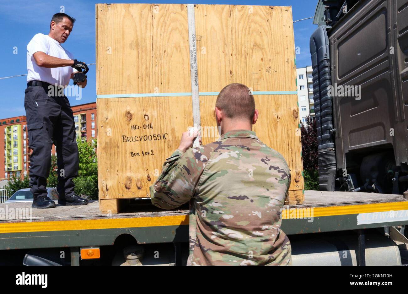 Matthew Williams, chief of the Camp Bondsteel Fire Department, and 1st Lt. Jacob Bruggeman, officer in charge of the Kilo 21 Liaison Monitoring Team, Regional Command-East, Kosovo Force, open a crate of hoses in Ferizaj/Urosevac, Kosovo, on June 3, 2021. The CBS Fire Department and Kilo 21 worked together to donate 140 sections of hoses to the municipality’s only firefighting team. Stock Photo