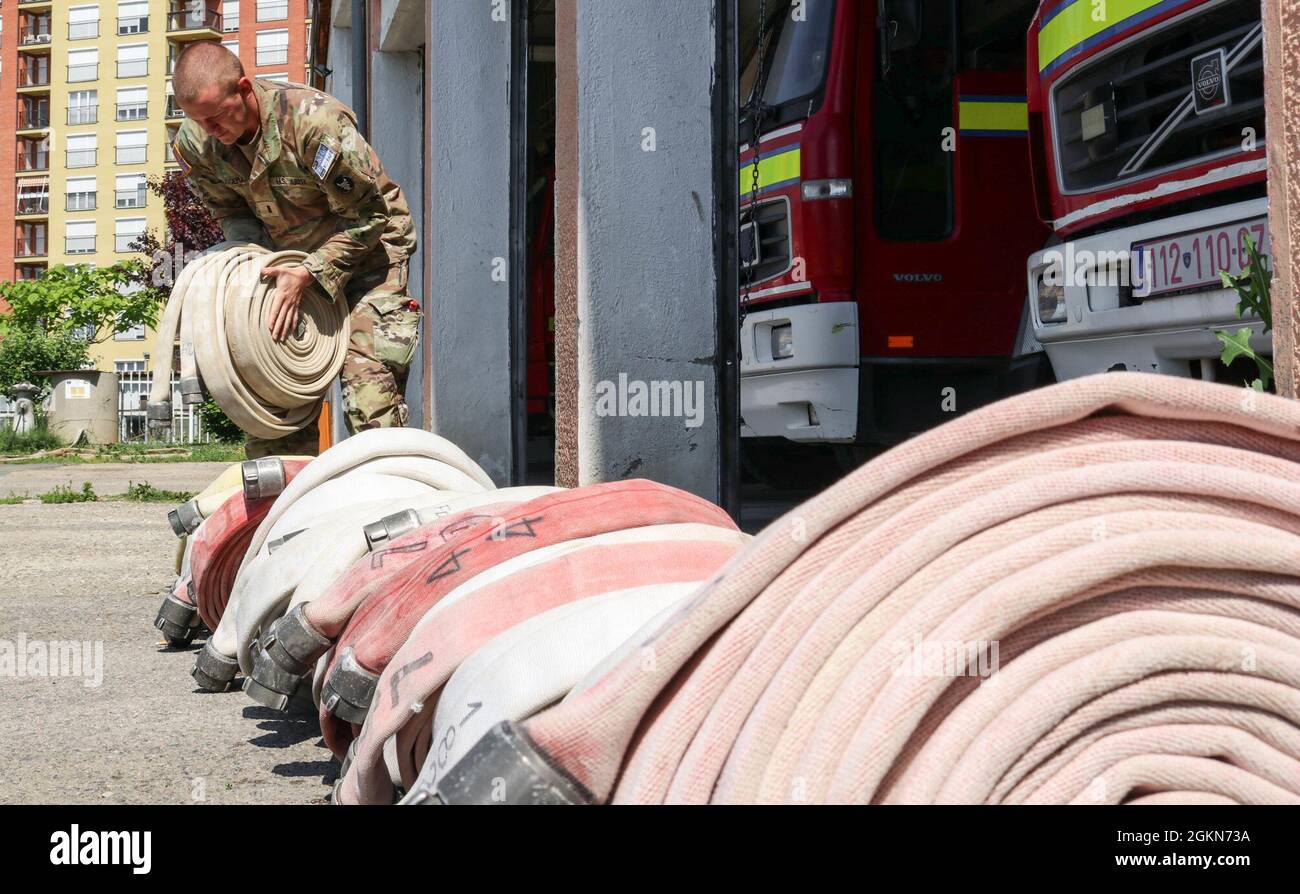 1st Lt. Jacob Bruggeman, officer in charge of the Kilo 21 Liaison Monitoring Team, Regional Command-East, Kosovo Force, helps unload hoses at the Fire Department in Ferizaj/Urosevac, Kosovo, on June 3, 2021. The Camp Bondsteel Fire Department and Kilo 21 worked together to donate 140 sections of hoses to the municipality’s only firefighting team. Stock Photo