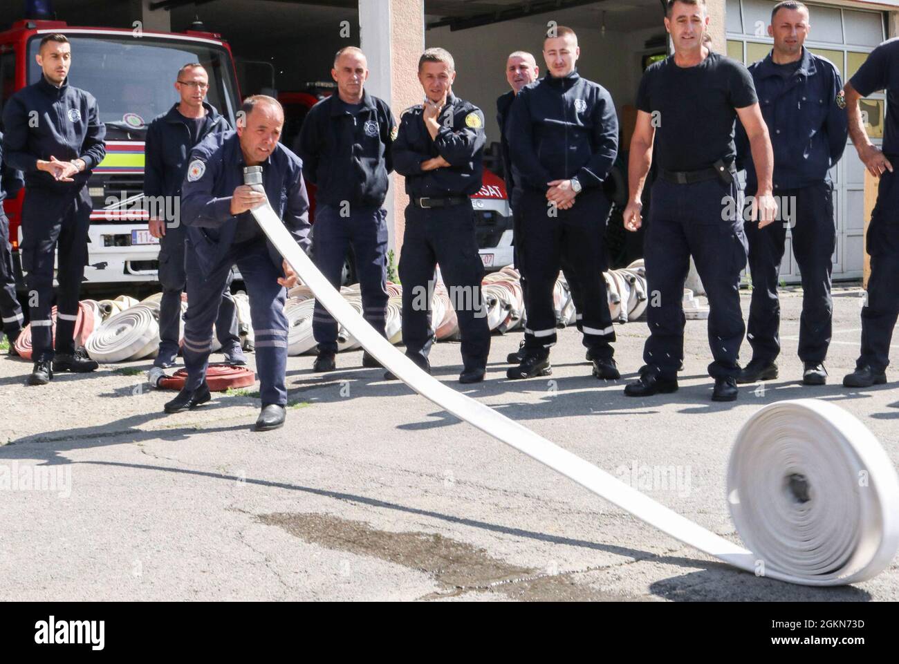 A member of the Ferizaj/Urosevac Fire Department unrolls a hose in Kosovo on June 3, 2021. Working through the Kilo 21 Liaison Monitoring Team assigned to Regional Command-East, Kosovo Force, the Camp Bondsteel Fire Department donated 140 sections of hoses to the municipality’s only firefighting team. The CBS team showed the local station how to properly deploy, attach, use and store the hoses. Stock Photo