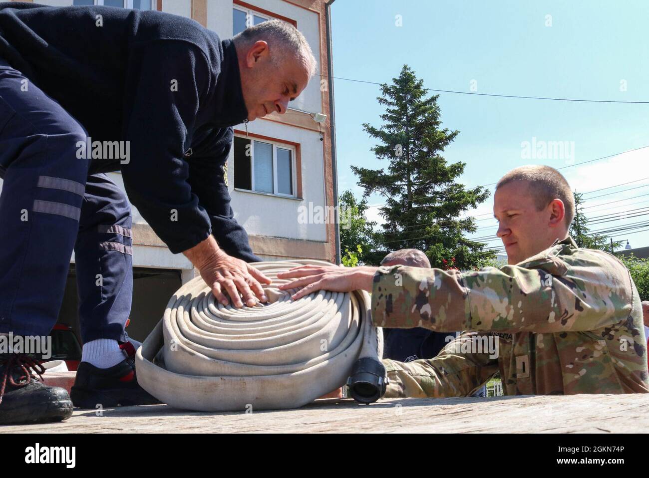1st Lt. Jacob Bruggeman, officer in charge of the Kilo 21 Liaison Monitoring Team, Regional Command-East, Kosovo Force, helps unload hoses at the Fire Department in Ferizaj/Urosevac, Kosovo, on June 3, 2021. The Camp Bondsteel Fire Department and Kilo 21 worked together to donate 140 sections of hoses to the municipality’s only firefighting team. Stock Photo
