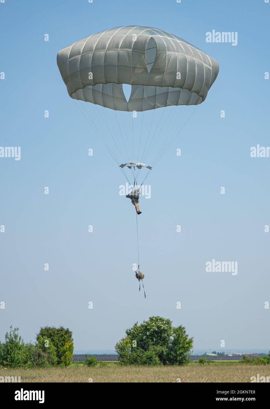 A British Army paratrooper assigned to Charlie (Bruneval) Company, 2 PARA prepares to land at Juliet Drop Zone during sustained airborne training, June 3, 2021. This training gave all participating paratroopers the opportunity to learn from each other and see each others tactics, techniques and procedures.     The 173rd Airborne Brigade is the U.S. Army's Contingency Response Force in Europe, providing rapidly deployable forces to the United States Europe, Africa and Central Command areas of responsibility. Forward deployed across Italy and Germany, the brigade routinely trains alongside NATO Stock Photo