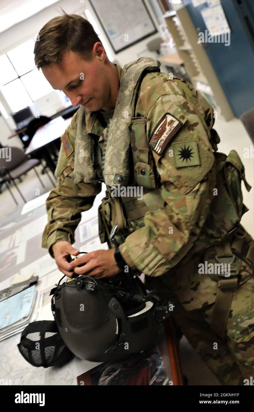 U.S. Army 1st Lt. Austin Rompel, a UH-60M Black Hawk helicopter pilot and aviation officer with the 1st Assault Helicopter Battalion, 140th Aviation Regiment, checks his flight helmet and equipment at Joint Forces Training Base, Los Alamitos, California June 5, 2021. Stock Photo