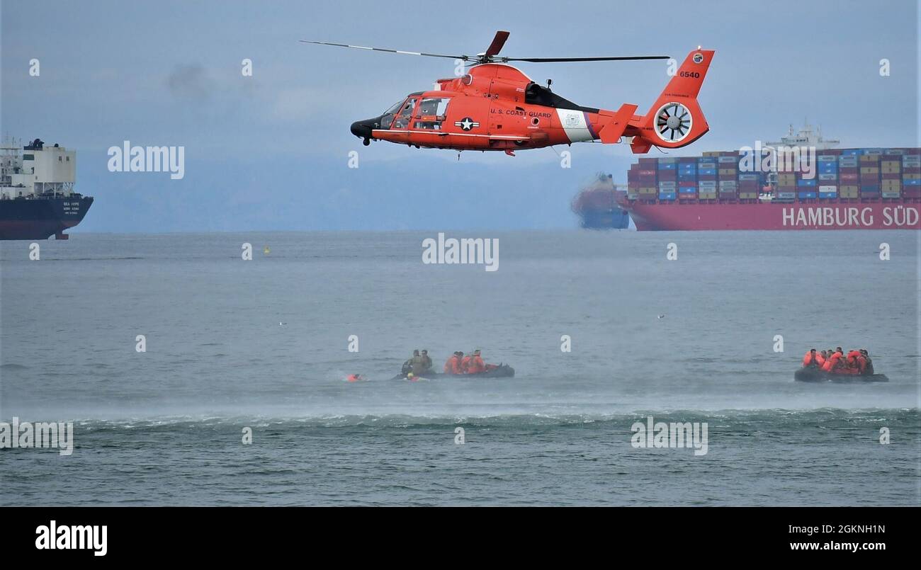A U.S. Coast Guard MH-65 Dolphin helicopter hovers over the ocean off the coast of Seal Beach, California, June 5, 2021. USCG practiced hoist rescues with Soldiers assigned to California Army National Guard’s 1st Assault Helicopter Battalion, 140th Aviation Regiment. Stock Photo
