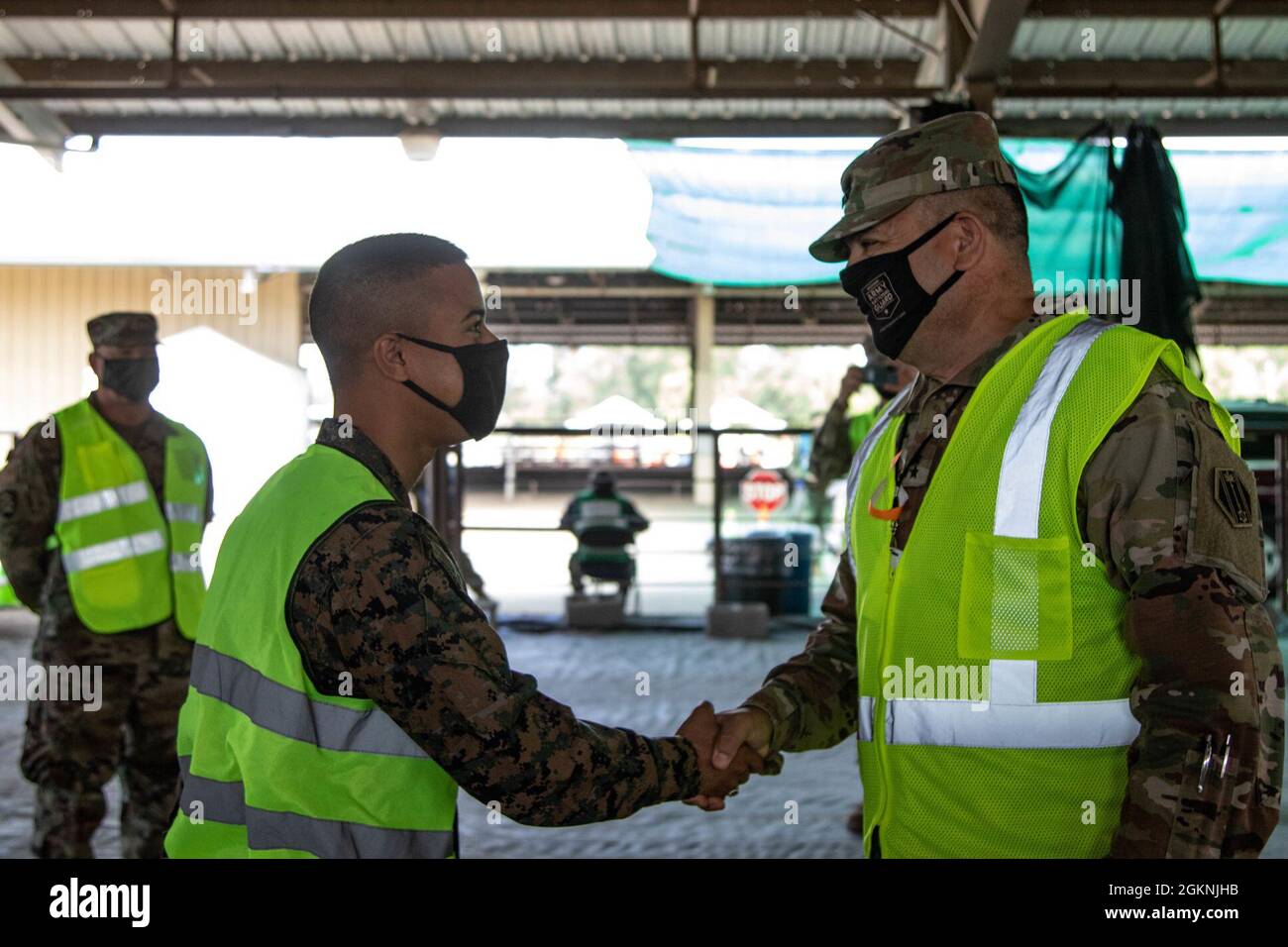 U.S. Army Maj. Gen. Pablo Estrada, commanding general of Task Force 46, Michigan National Guard, right, coins Marine Cpl. Osvaldo Costas, assigned to Task Force Benfold, I Marine Expeditionary Force, left, in Medford, Oregon, June 6, 2021. Costas helped administer 130 vaccinations and assisted with Spanish language translation. He deployed with service members from the Army, Marines, Navy and Coast Guard to assist in the federal vaccine response effort for Jackson County, Oregon. U.S. Northern Command, through U.S. Army North, remains committed to providing continued, flexible Department of De Stock Photo