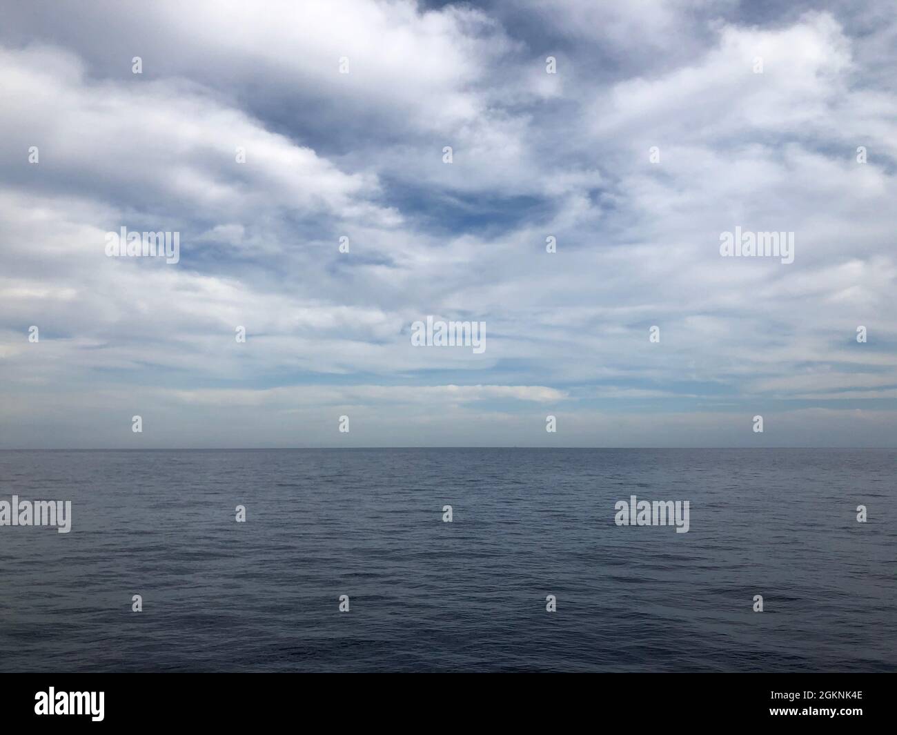 Dark blue clouds and sea or ocean water surface with foam waves before ...