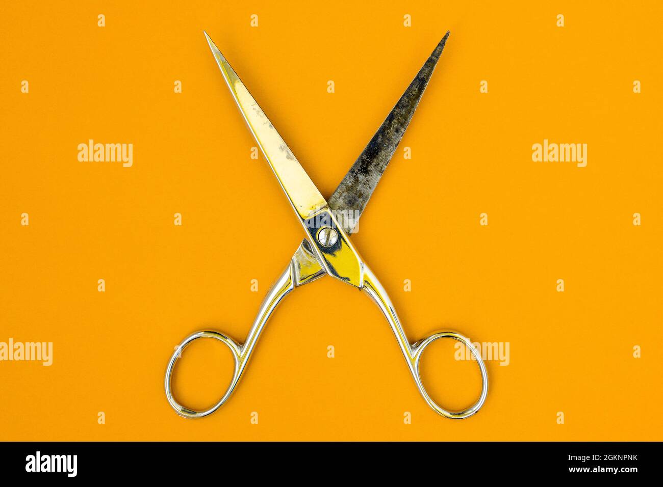 Very sharp retro professional tailor scissors on yellow background Stock Photo