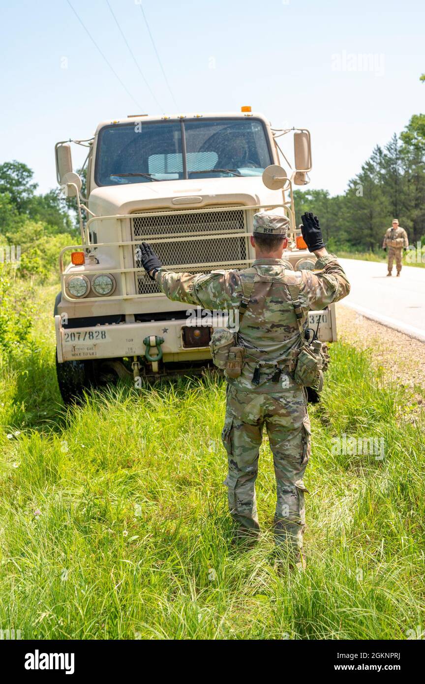 Staff Sgt. James Dean, an observer coach/trainer with 1st Battalion, 310th Brigade Engineer Battalion, 181st Multifunctional Training Brigade, ground guides an M915A5 Line-Haul Tractor Truck from a ditch on the side of a road June 8, 2021, on Fort McCoy, Wis. The vehicles needed to be safely driven out of the ditch without compromising each truck’s tipping point angle. Stock Photo