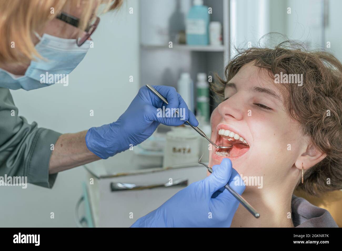 Dentist doctor examines the health of teeth of teenage girl in dental office Stock Photo