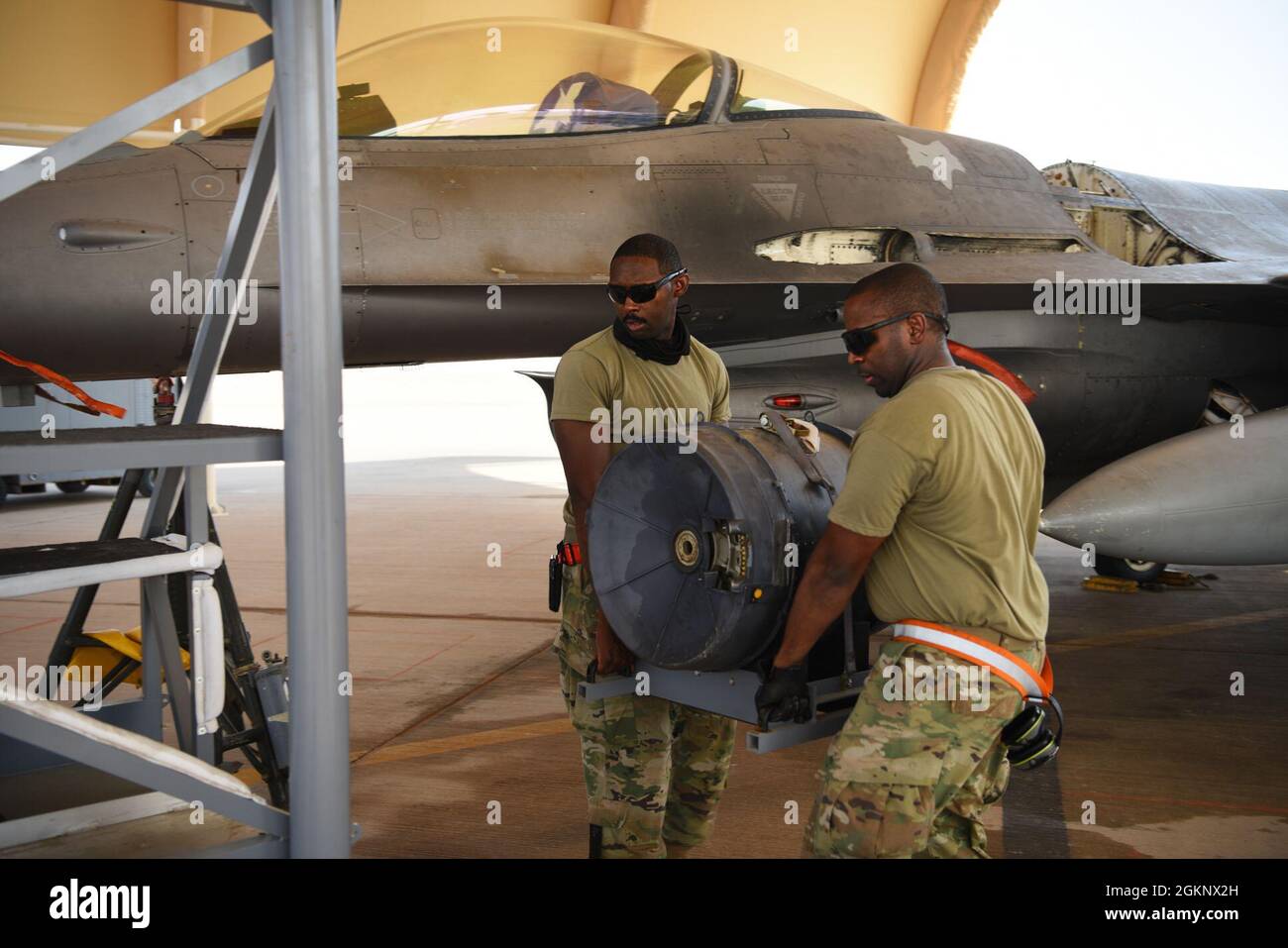 U.S. Air Force Staff Sgt. Kajuan Archer (left) and U.S. Air Force Staff Sgt. Rick Ingram, 378th Expeditionary Maintenance Squadron armament backshop personnel, remove parts of an M61A1 Vulcan cannon from an F-16 Fighting Falcon fighter jet at Prince Sultan Air Base, Kingdom of Saudi Arabia, June 8, 2021. The 'Swamp Fox' Airmen from the South Carolina Air National Guard are deployed to PSAB to project combat power and help bolster defensive capabilities against potential threats in the region. Stock Photo