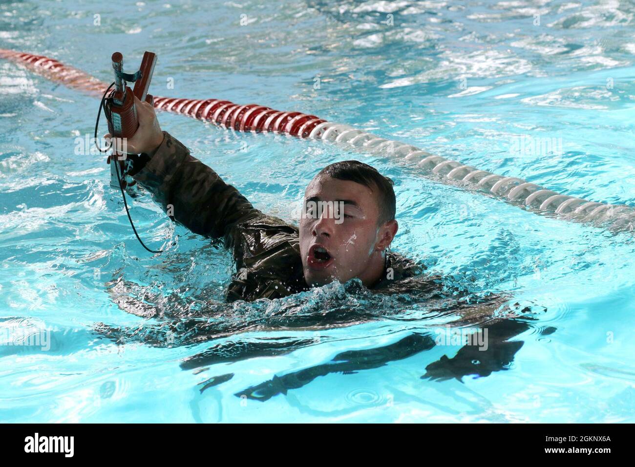 Soldiers assigned to 2nd Platoon, Apache Company, 1st Battalion, 102d Infantry (Mountain), 86th Infantry Brigade Combat Team conduct the Army Combat Water Survival Test (CWST) in Djibouti, June 8, 2021. The CWST consists of a 15-meter swim with equipment and weapon, 3-meter drop and pool exit, and underwater equipment removal. The three events are executed in sequence with up to ten minutes allowed between events.  Apache Company serves as the East Africa Response Force (EARF), which provides a combat-ready rapid deployment capability to support crisis operations in the U.S. Africa Command Are Stock Photo