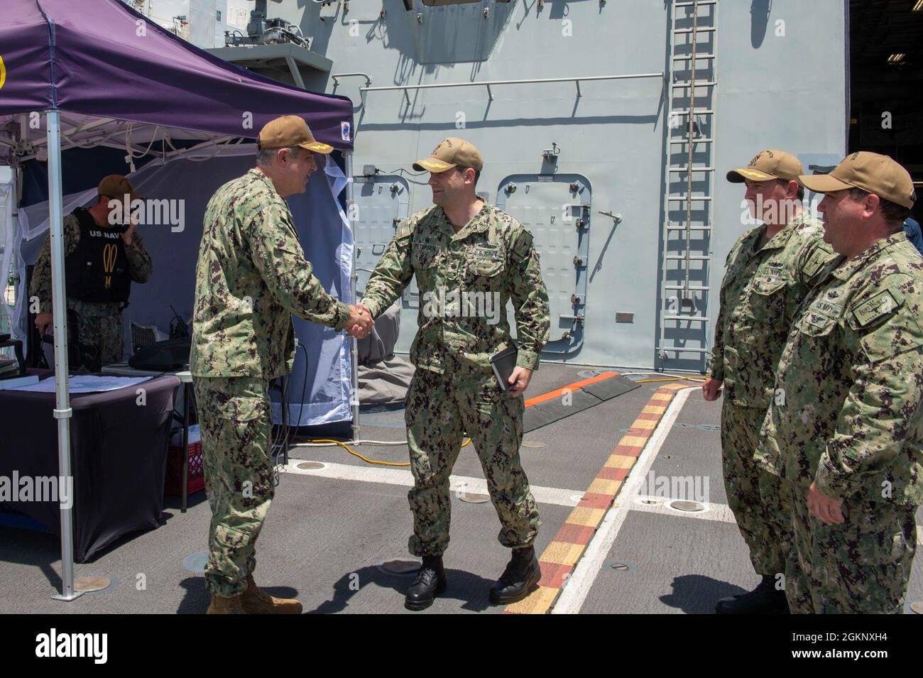 210609-N-ZS023-1008 NAVAL BASE SAN DIEGO (JUNE 8, 2021) Cmdr. Jeremiah Petersen, center, commanding officer of Freedom-variant littoral combat ship USS Fort Worth (LCS 3), greets Capt. Gregory Thier, left, Force Surgeon, Naval Surface Force, U.S. Pacific Fleet, for a scheduled tour. The LCS is a fast, agile, mission-focused platform designed to operate in near-shore environments, winning against 21st-century coastal threats. Stock Photo