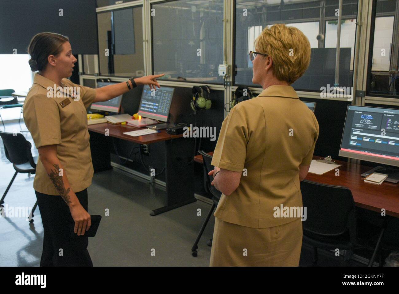 PENSACOLA, Fla. (June 9, 2021) Naval Aircrewman (Mechanical) 1st Class Natasha Kraniak, an Aviation Survival Training Center (ASTC) instructor, guides Rear Adm. Cynthia Kuehner, Commander, Naval Medical Forces Support Command (NMFSC), on a tour of a normobaric hypoxia trainer as a part of her visit to Navy Medicine Operational Training Command (NMOTC). The mission of NMOTC is to provide training for operational medicine and aviation survival. Support the Fleet and Fleet Marine Force with operational medicine consultative services, conduct education and training programs for medical department Stock Photo