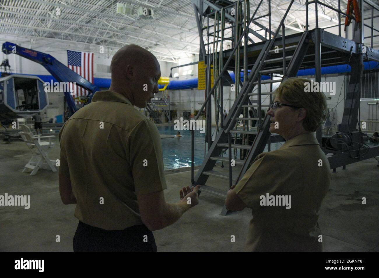 PENSACOLA, Fla. (June 9, 2021) Naval Aircrewman (Helicopter) 2nd Class Bret Bristol, an Aviation Survival Training Center (ASTC) instructor, guides Rear Adm. Cynthia Kuehner, Commander, Naval Medical Forces Support Command (NMFSC), on a tour of the ASTC pool as a part of her visit to Navy Medicine Operational Training Command (NMOTC). The mission of NMOTC is to provide training for operational medicine and aviation survival. Support the Fleet and Fleet Marine Force with operational medicine consultative services, conduct education and training programs for medical department personnel in vario Stock Photo