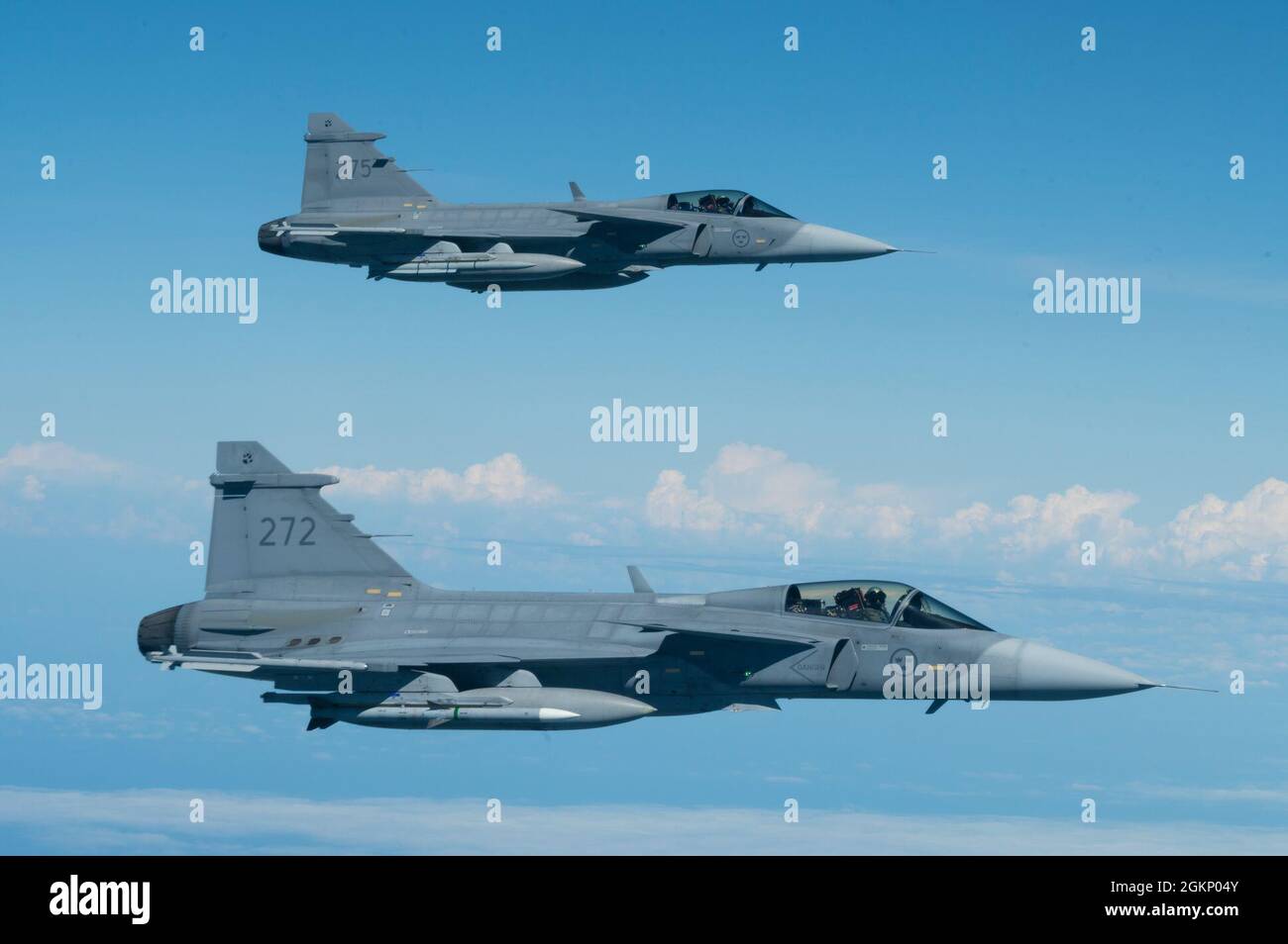 Two Swedish Saab JAS 39 Gripen fighter jets escort a B 52H