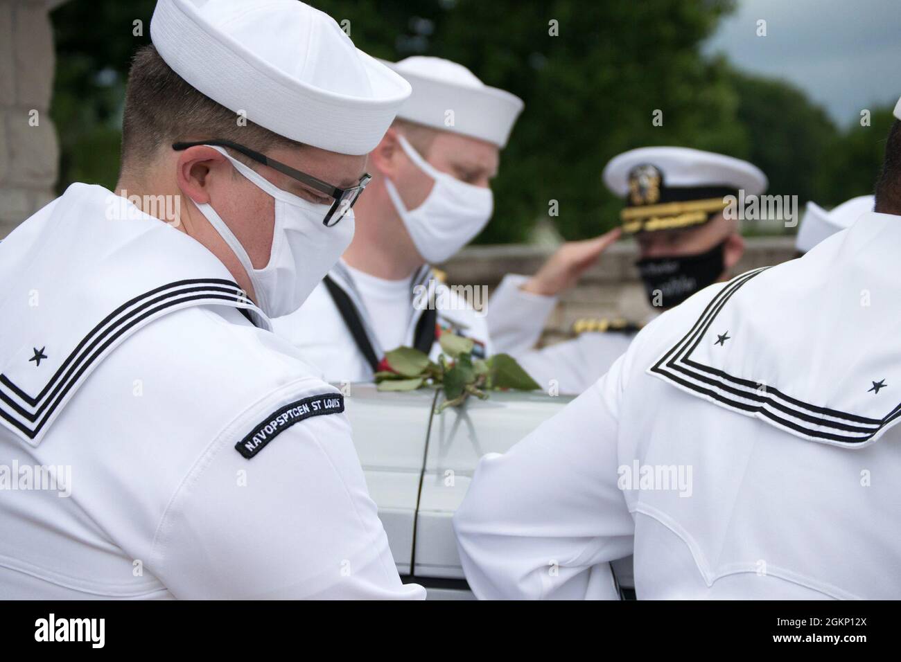 210608-N-PO345-5922 ST LOUIS. (June 8, 2021) – Pallbearers Hospital Corpsman 2nd Class David Manthei, Personnel Specialist 1st Class Nicholous Andrews, and Hospital Corpsman 2nd Class Robert Miller from Navy Operational Support Center St. Louis, transfer the casket of Navy Mess Attendant 3rd Class Isaac Parker’s to it’s final resting place at Jefferson Barracks National Cemetery in St. Louis, MO, June 8, 2021. Parker was killed aboard the USS Oklahoma (BB-37) when it received up to eight torpedo hits and capsized in less than 12 minutes during the attack on Pearl Harbor, HI, December 7, 1941. Stock Photo