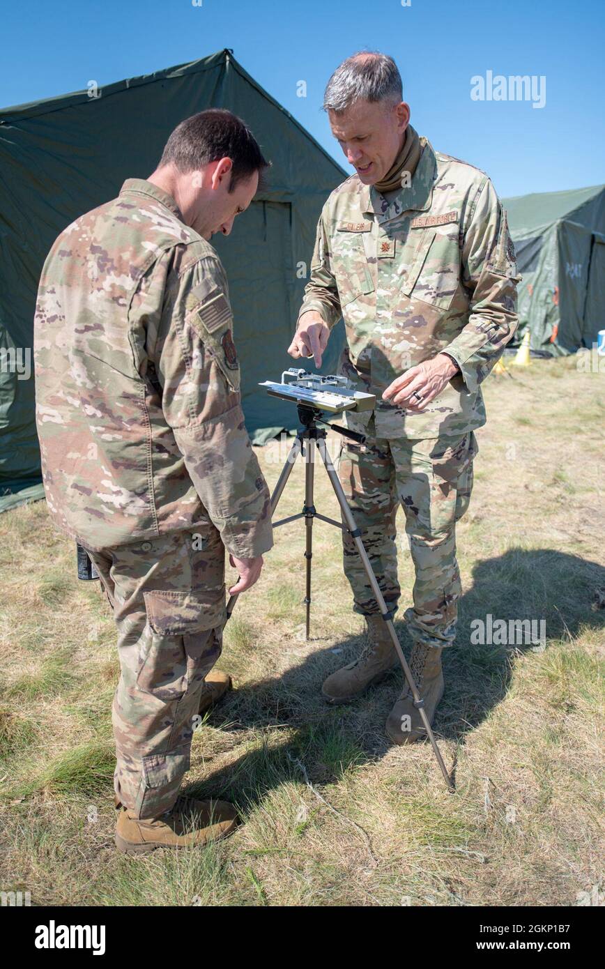 Maj. Kevin Eilers (right), bio-environmental engineer for the Kentucky Air National Guard’s 123rd Contingency Response Group, demonstrates how to use a wet bulb globe temperature apparatus to Master Sgt. Peter Vicini during Operation Lone Oak at Volk Field, Wis., June 9, 2021. The apparatus takes temperature readings to determine work-rest cycles during certain weather conditions, which became crucial for safety during an unprecedented heat wave over the course of the exercise. Stock Photo