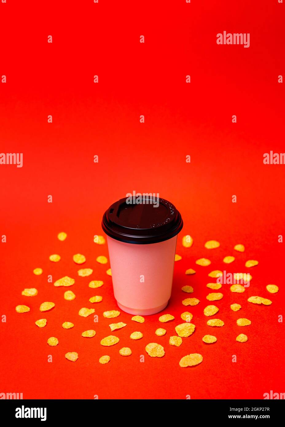 white paper cup with corn flakes on a red background Stock Photo - Alamy