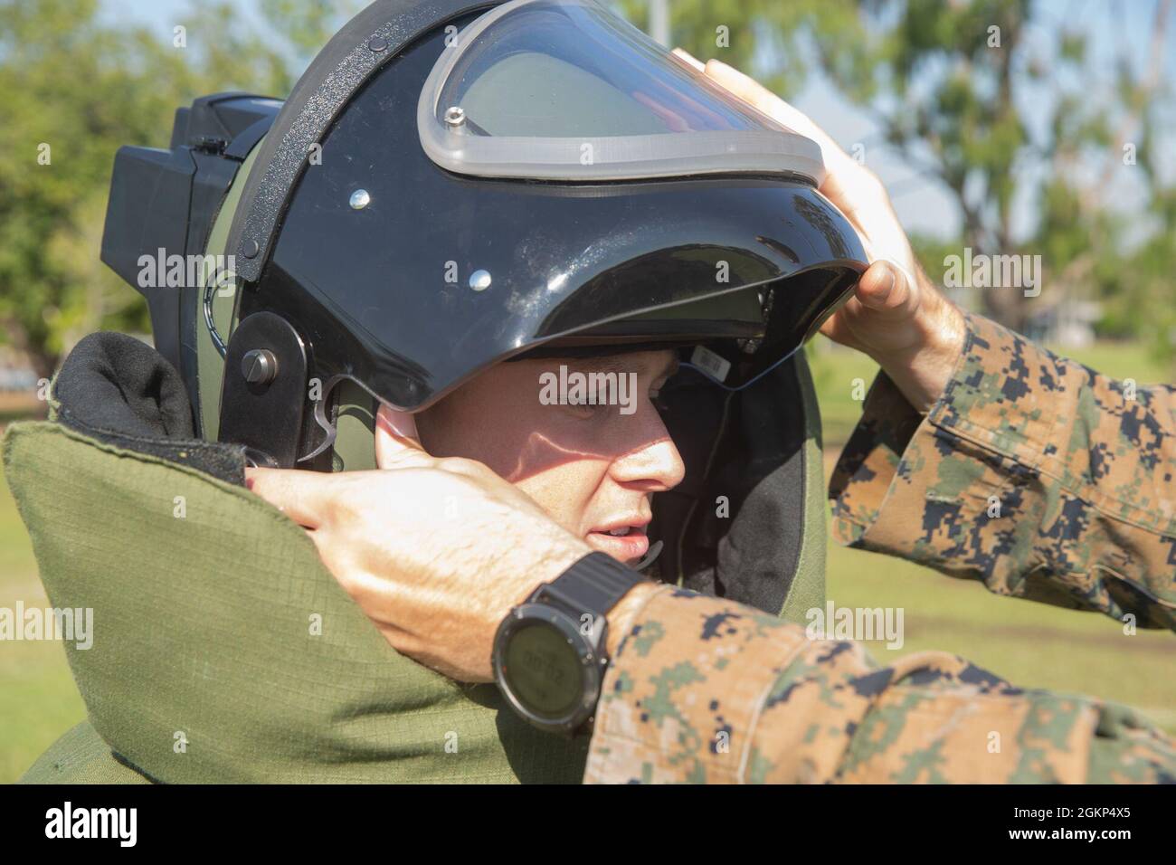 U.S. Marine Corps Sgt. Christian Rutledge, a parachute rigger with Marine Rotational Force - Darwin, receives operating instructions for a blast resistant helmet during an Explosive Ordnance Disposal lateral move screener at Robertson Barracks, Darwin, NT, Australia, June 10, 2021. The screener consisted of bomb suit training, ordinance identification, and rope techniques. Stock Photo
