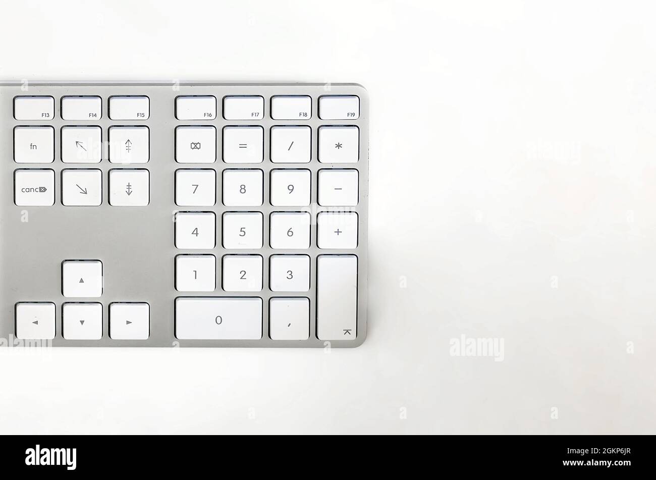 Detail of a modern white computer keyboard on a white table. Computer hardware device. Technology and internet Stock Photo
