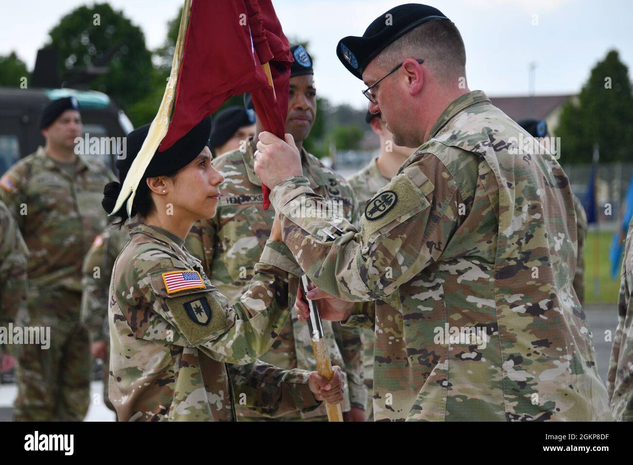 U.S. Army Col. E. Lee Bryan, right, U.S. Army Medical Department Activity Bavaria commander, passes the unit colors over to the U.S. Army Health Clinic Grafenwoehr incoming commander Lt. Col. Crista Wagner, during the Clinic’s Change of Command Ceremony at Tower Barracks, Grafenwoehr, Germany, June 11, 2021. Stock Photo