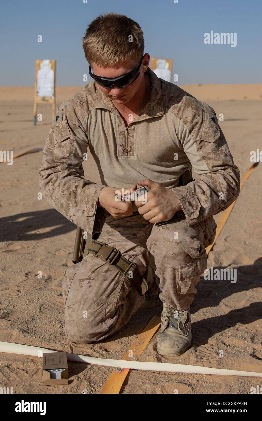 A U.S. Marine, with 2nd Battalion, 1st Marine Regiment, assigned to Special Purpose Marine Air-Ground Task Force – Crisis Response – Central Command (SPMAGTF-CR-CC), fills a magazine during a pistol range in the Kingdom of Saudi Arabia, June 11, 2021. The pistol range allowed for Marines to qualify and test their accuracy with small firearms. The SPMAGTF-CR-CC is a crisis response force, prepared to deploy a variety of capabilities across the region. Stock Photo