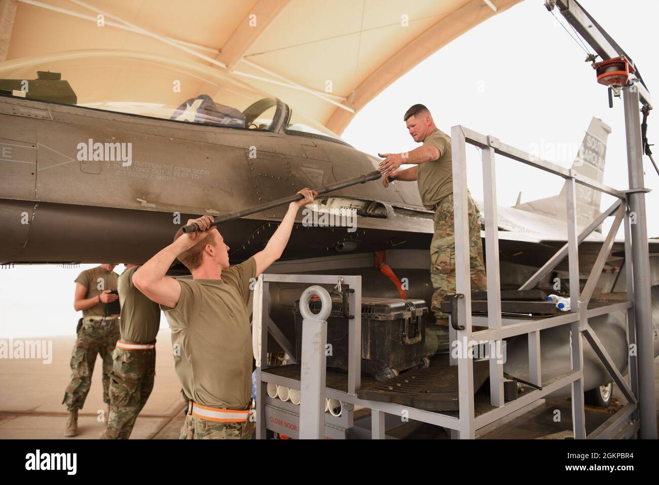 U.S. Air Force Master Sgt. Adam Chavis (right), receives the barrel of an M61A1 Vulcan cannon from U.S. Air Force Airman 1st Class Brice Padgett, 378th Expeditionary Maintenance Squadron armament backshop personnel, reinstalling an M61A1 Vulcan cannon into an F-16 Fighting Falcon fighter jet at Prince Sultan Air Base, Kingdom of Saudi Arabia, June 11, 2021. The 'Swamp Fox' Airmen from the South Carolina Air National Guard are deployed to PSAB to project combat power and help bolster defensive capabilities against potential threats in the region. Stock Photo