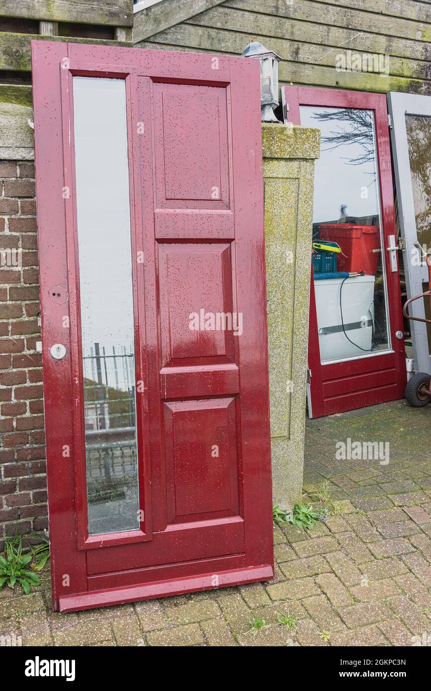 two red front doors in a backyard Stock Photo