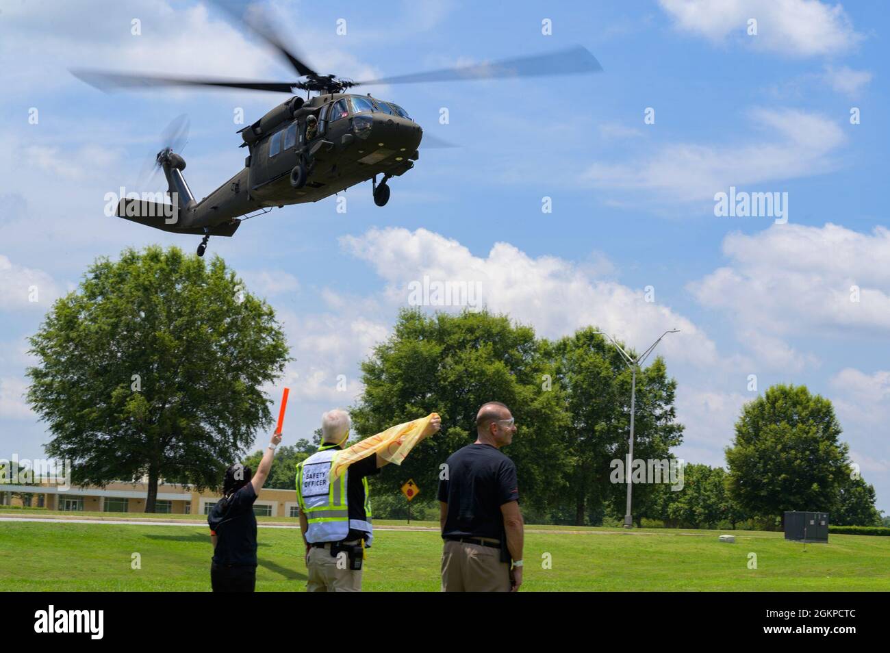 Members of the helicopter landing crew guide in a UH-60 Black Hawk helicopter to a landing zone at Central Georgia Technical College, Warner Robins, Georgia, June 12, 2021. Nearly 50 personnel with the 116th Medical Group, Detachment 1, trained with civilian medical professionals and local authorities to respond to a mass casualty scenario in a two-day exercise. Stock Photo