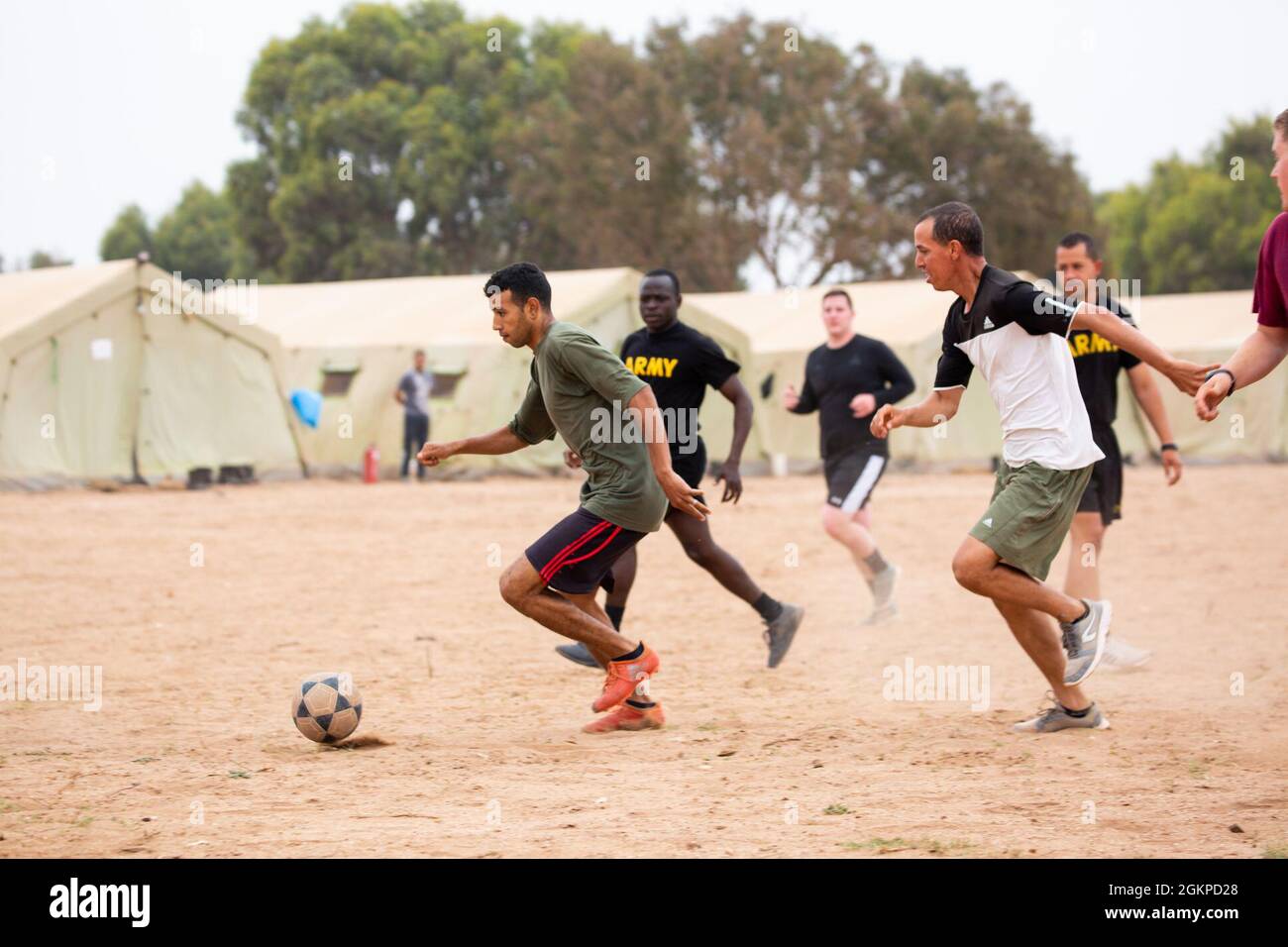 Unites States soldiers from the 19th Special Forces Group, 551st Military Police Company, 716th Military Police Battalion and Royale Moroccan Forces play soccer together to take a break from the Africa Lion 21 Exercise Training at Camp Tifnit on June 12, 2021. African Lion 2021 is U.S. Africa Command's largest, premier, joint, annual exercise hosted by Morocco, Tunisia and Senegal, 7-18 June. More than 7,000 participants from nine nations and NATO train together with a focus on enhancing readiness for U.S. and partner nation forces. AL21 is a multi-domain, multi-component, and multinational ex Stock Photo