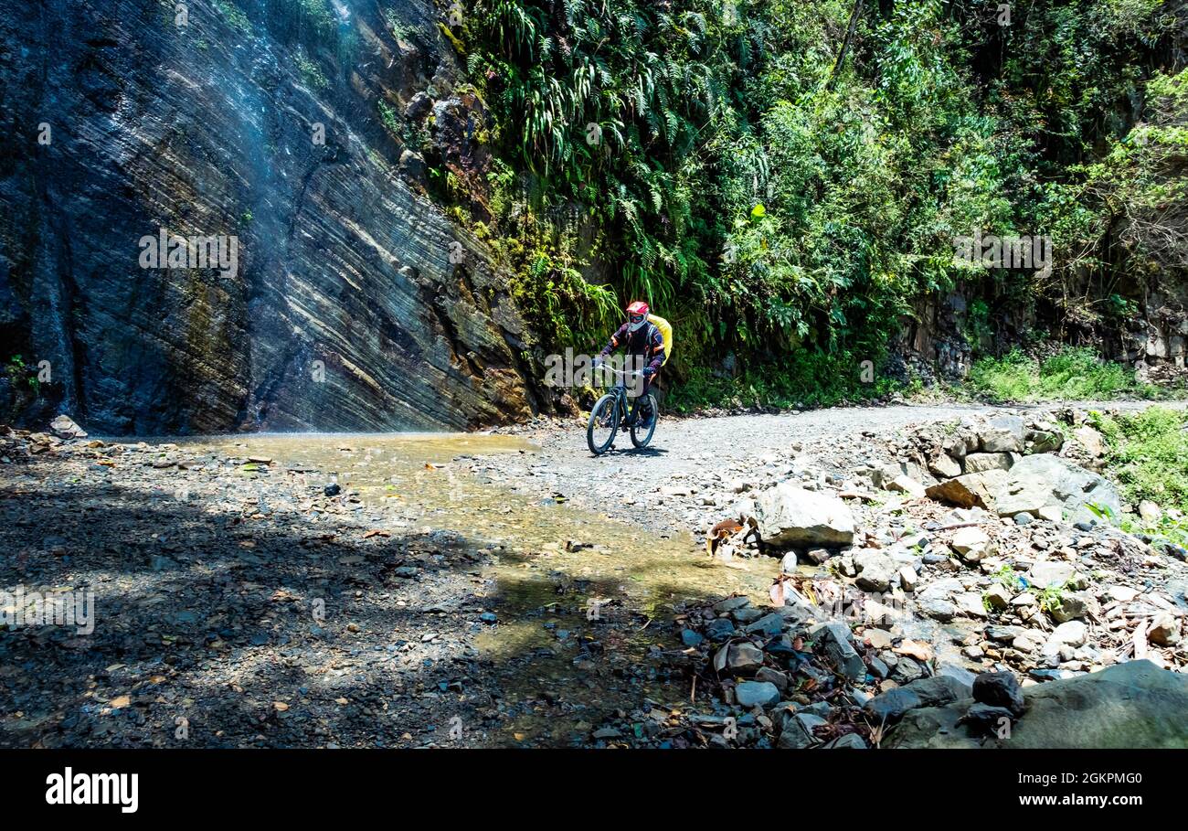 Man riding a bike on the sunshine Bolivian death road Stock Photo